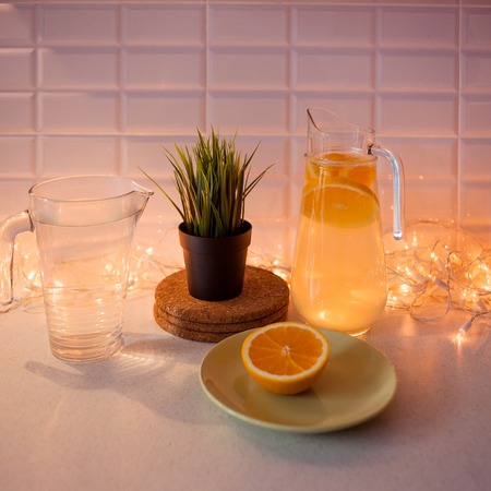 Homemade lemonade in the decanter. Christmas winter kitchen, comfortable interior