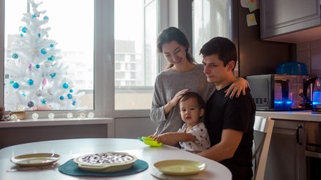 Young happy family for a festive dinner. Happy multi-ethnic family at home in the kitchen