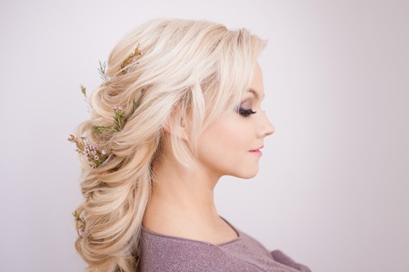 Portrait of gentle young woman with blond hair. Trendy hairstyle, natural hair styling