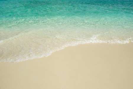 Secluded island. Paradise tropical island, white sand and clear water. Waves on the background of...