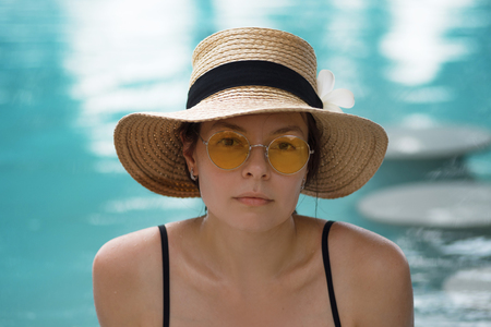 Portrait of a young woman on vacation. Girl in a straw hat and sunglasses on the background of the...
