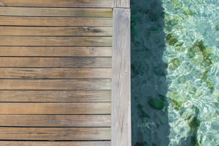 Boardwalk and clear blue water. Clean sea coral reefs. Mockup with free space in the center