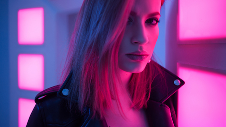Futuristic style portrait in blue and purple light. Fashion portrait of trendy young woman in...