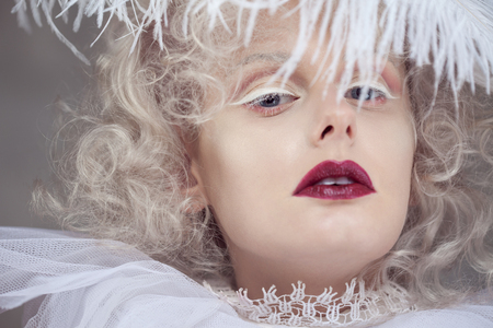 Young attractive woman with platinum blonde and purple lipstick. Fantasy style portrait of a lady with white curls and a lace collar.の写真素材