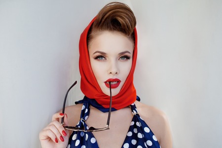 young beautiful woman with red lipstick and a headscarf. Pin-up portraitの写真素材