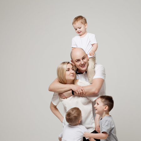 Big and funny family, mom dad and three sons. Happy together. family portrait on light grey background.の写真素材