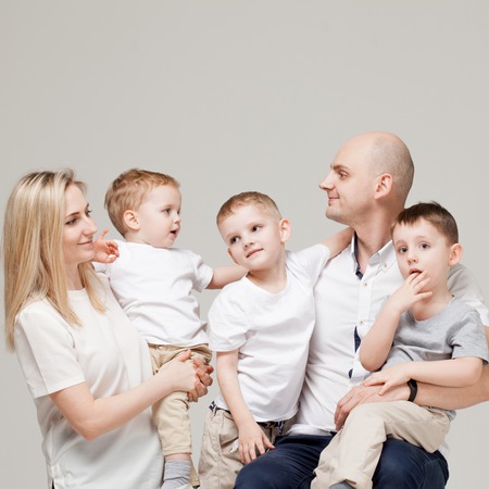 Big and cheerful family, mom dad and three sons. Happy together. family portrait on light grey background.の写真素材