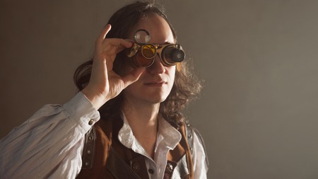 Steampunk style researcher mechanist of the monocle with a large number of lenses looking at something. copy space on the rightの写真素材