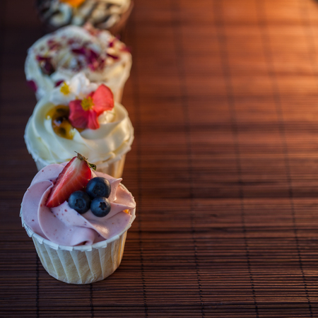 Beautiful and delicious cupcakes on the table. A set of delicious sweet desserts with cream.の写真素材