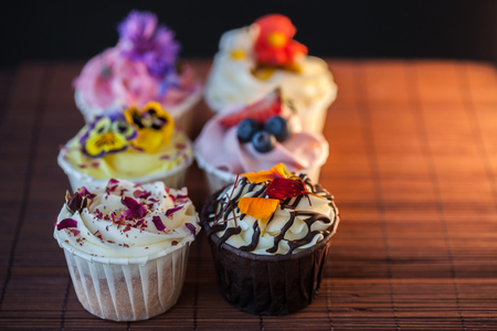 Beautiful and delicious cupcakes on the table. A set of delicious sweet desserts with cream.の写真素材