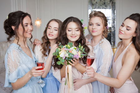 Girlfriends hug bride, bachelor party. Happy beautiful girls in the apartmentの写真素材