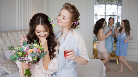 Young beautiful brunette at a bachelor party. A young woman with a bouquet of flowers, a girl with friends celebrating.の写真素材