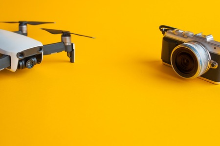 Drone for aerial photography and mirrorless camera set to create cool pictures. Yellow background and copy spaceの写真素材