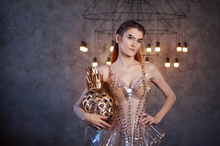 Young woman from the future, concept. Dress made of transparent plastic and artificial food....