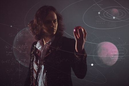 Physics the science of nature, the concept of studying the laws of nature. A young man in the image of Isaac Newton. With an Apple in hand, the concept of the laws of gravity.の写真素材