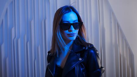 Beautiful girl dancing in retro wave on the neon light. Fashion portrait of trendy young woman in...