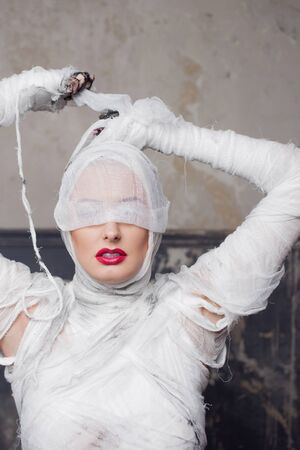 Mummy girl blindfolded. Portrait of a young beautiful woman in bandages all over her body. Halloween...