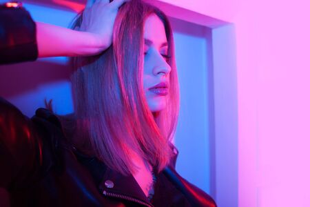 Futuristic style portrait in blue and purple light. Fashion portrait of trendy young woman in...