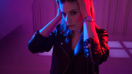 Beautiful girl dancing in retro wave on the neon light. Fashion portrait of trendy young woman in...