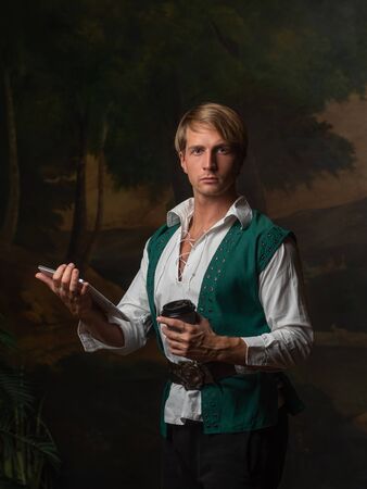 Young man in Renaissance style uses gadgets. funny duet of medieval style and modern attributes,...