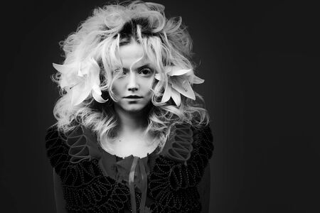 Attractive blonde woman, with a lush hairstyle with white lily flowers in her hair. Copyspace.の写真素材