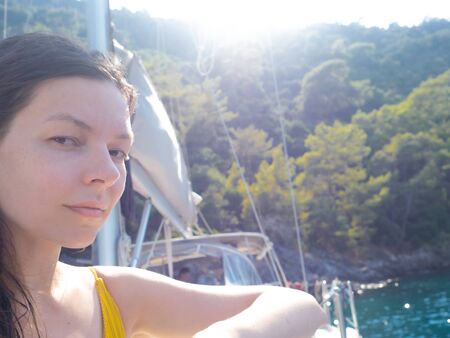 Happy young woman resting on the sea, portrait on the deck of a yacht. Boat tripの写真素材