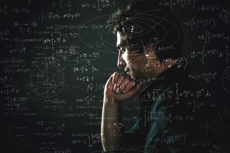 Training and research, concept. Pensive man and physical and mathematical formulas on the backgroundの写真素材