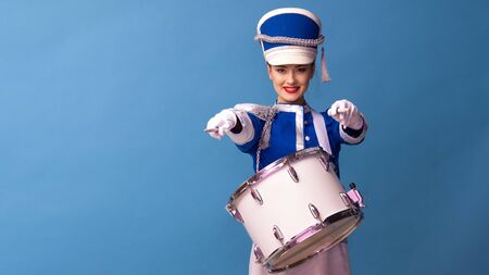 drummer in a blue uniform drums on a drum, show program and celebration. Funny drummer plays drums and sings, joy and celebrationの写真素材