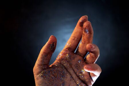 Female hand covered with sequins. The movement of the palm of your hand and Shine multicolored...
