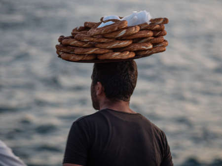 ISTANBUL, TURKEY - SEPTEMBER 21, 2019: Turkish bagel seller with a tray on his headのeditorial素材
