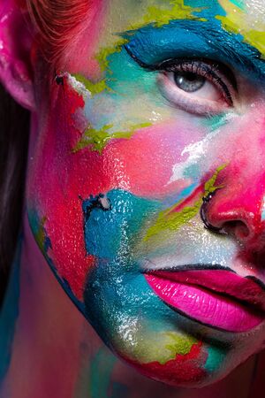 Multicolored skin, difficult to identify. Creative makeup with colorful patterns on the face. Fake...