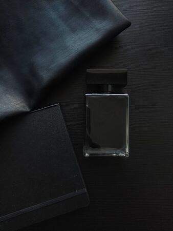 Perfume, Notepad and leather accessory, a set of daily things. Perfume in a black bottle, black on black, strict style layoutの写真素材