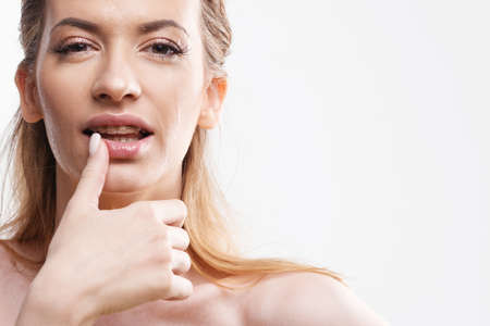 Wash your face and take care of your skin. Portrait of a young woman with beautiful clear skin, close-up on a white background. Skin care, copy spaceの写真素材