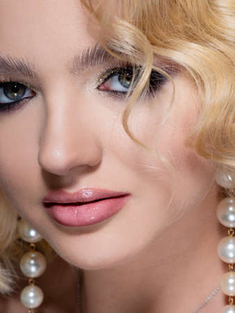 Gorgeous blonde, portrait on a black background. Beautiful young girl with stylish sexy make-up,...