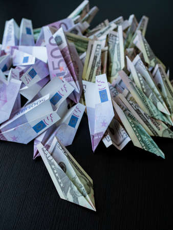 Cash flow, concept. A large pile of paper planes made from cash, dollars and euros. Investments and currency movements in the global economy, trading on currency pairsの写真素材