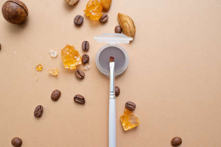Cosmetics for natural makeup,Eyebrow makeup products. Warm background with nuts coffee and dried...