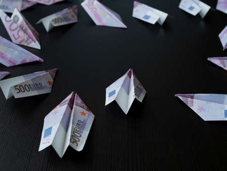 Paper airplanes made of Euro banknotes, the concept of cash flow. Global financial crisis, debt on...