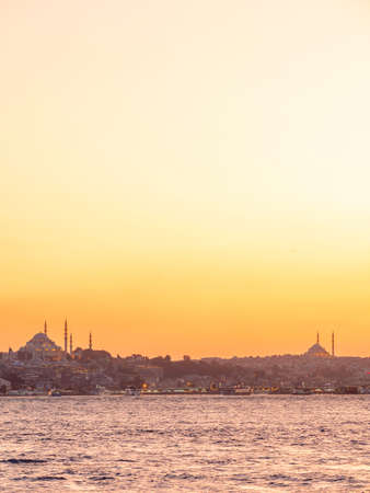 Evening view of the coast of Istanbul, silhouettes of mosques against the orange sky