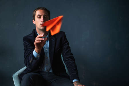 young man and orange paper planes. Entrepreneur or investor, development planning and financial strategiesの写真素材