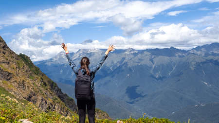 Embrace the world around, a young woman with a backpack in the mountains, Hiking in national parks