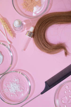 Eco-friendly and modern cosmetics for hair care, a set of ingredients and bottles on a pink background. Hair and combs.の写真素材