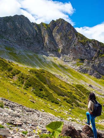 Unity with nature. Hiking in the mountains. Young woman traveling in the mountains, local tourism.