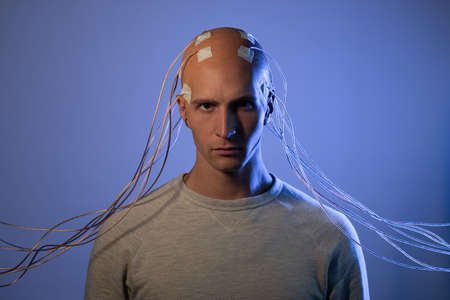 man with electrodes in his head is a futuristic concept of virtual reality and mind control. Neuro...
