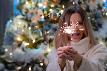 Fun and Bengal fire for the new year. A young woman is happy and celebrates new year or Christmasの写真素材