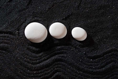 rock garden white pebbles on black sand, wavy patterns.の写真素材