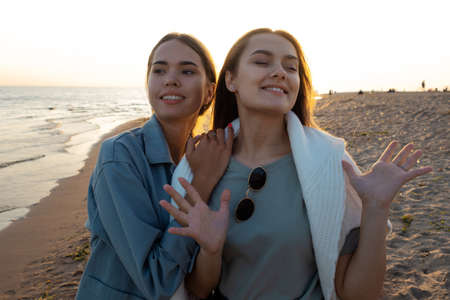 Friends have a happy time together. Young women on the beach in the evening,