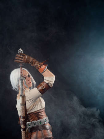 A young warrior with a sword on a dark background. Fantasy heroine