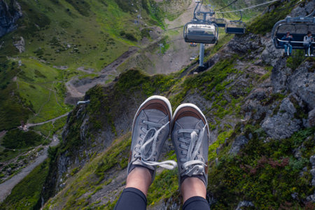 Mountain resort in summer, sneakers on the background of a mountain landscape, first-person photo.の写真素材