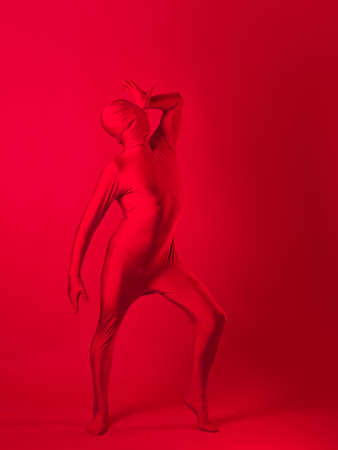 crazy red man on a red background. figure in a leotard covering the whole bodyの写真素材