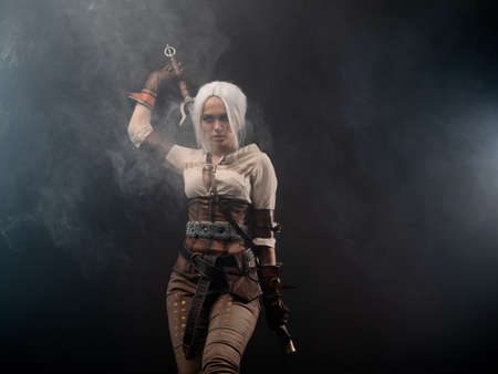 A young warrior with a sword on a dark background. Fantasy heroine